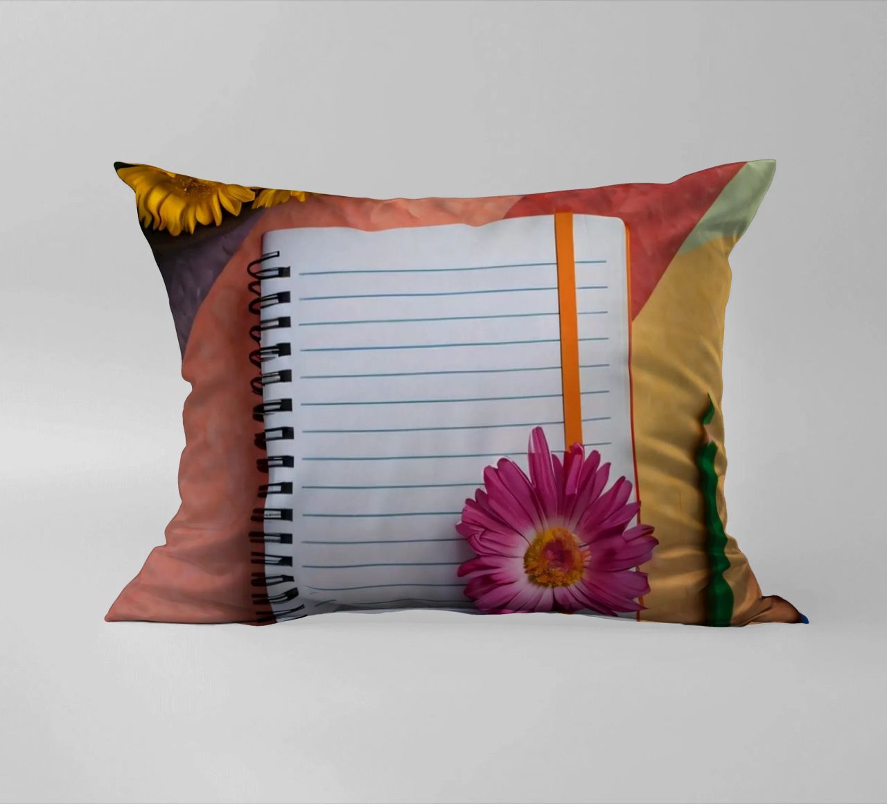 Uno spazio di lavoro colorato con un taccuino con un fiore cuscino da DesignDoodle