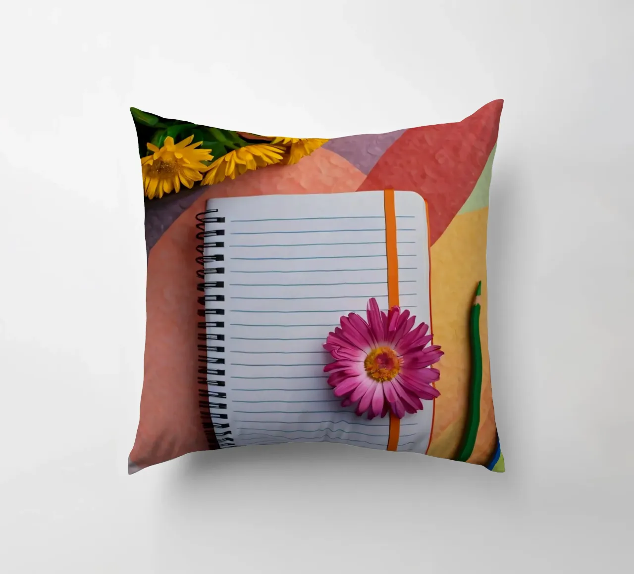 Espace de travail coloré comprenant un cahier avec une fleur coussin de DesignDoodle