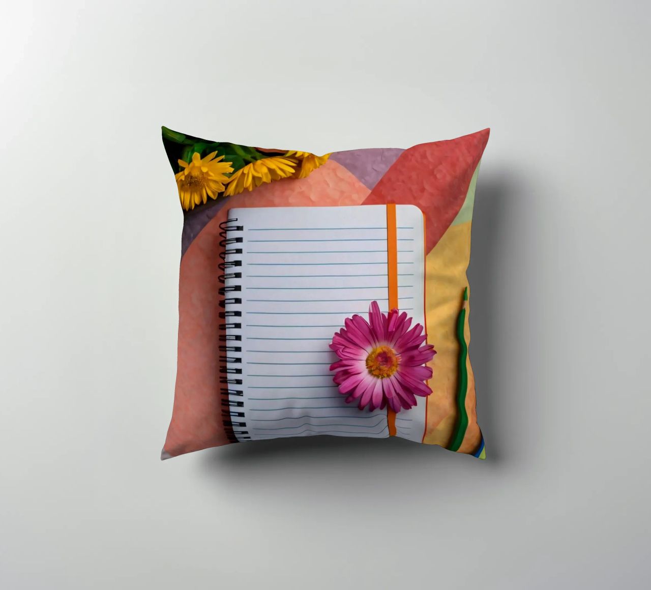 Uno spazio di lavoro colorato con un taccuino con un fiore cuscino da DesignDoodle