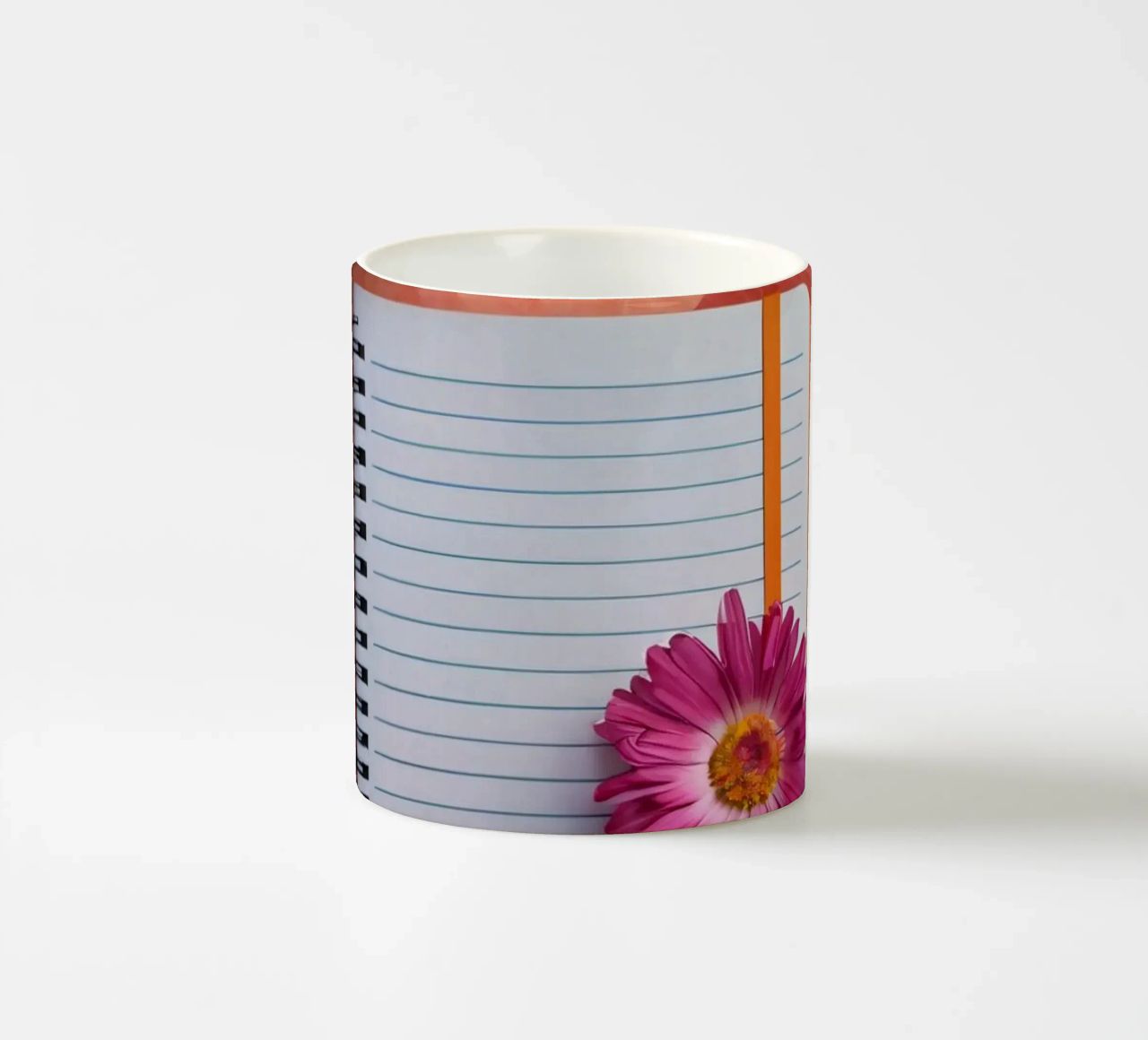 Uno spazio di lavoro colorato con un taccuino con un fiore tazza in ceramica da DesignDoodle