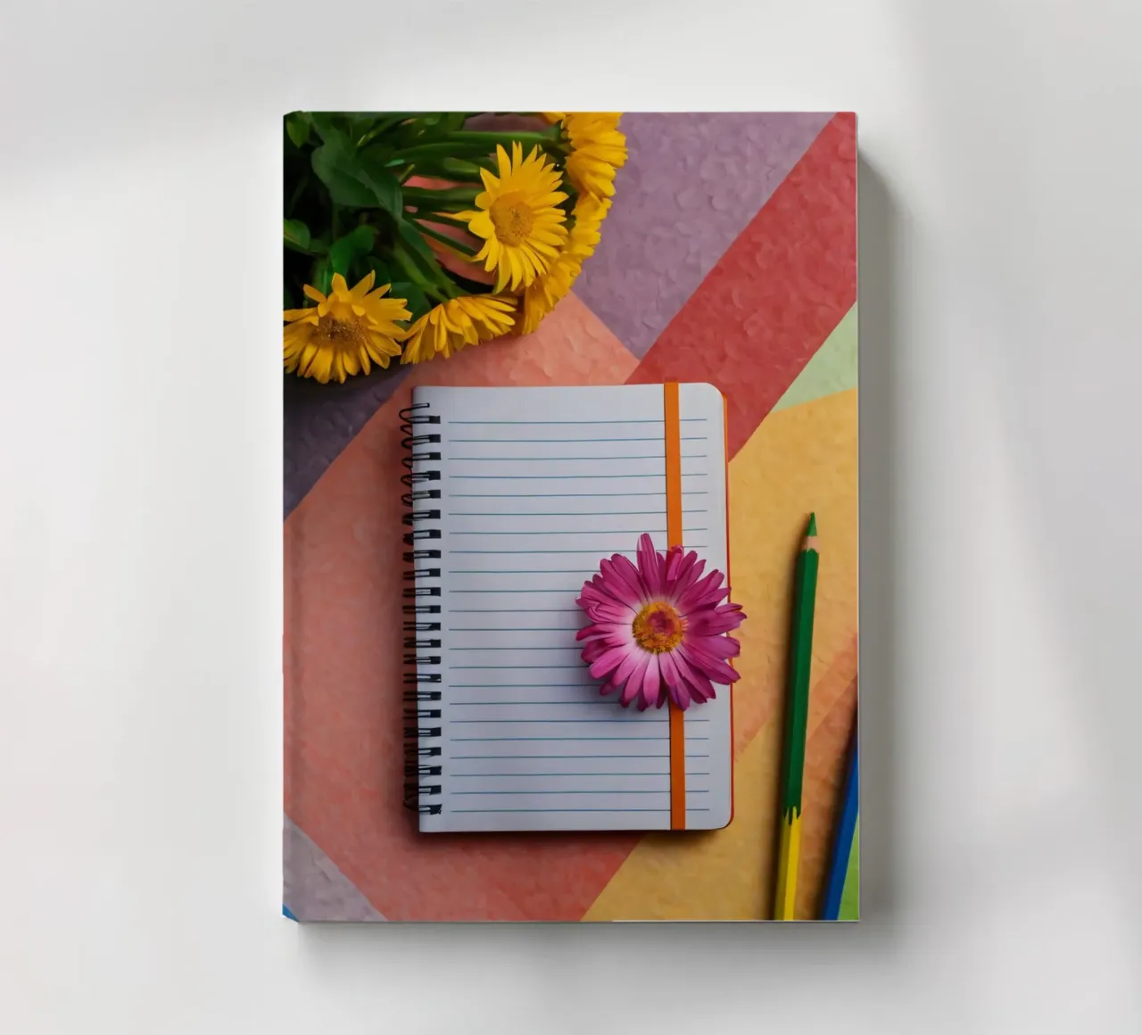Uno spazio di lavoro colorato con un taccuino con un fiore diario da DesignDoodle