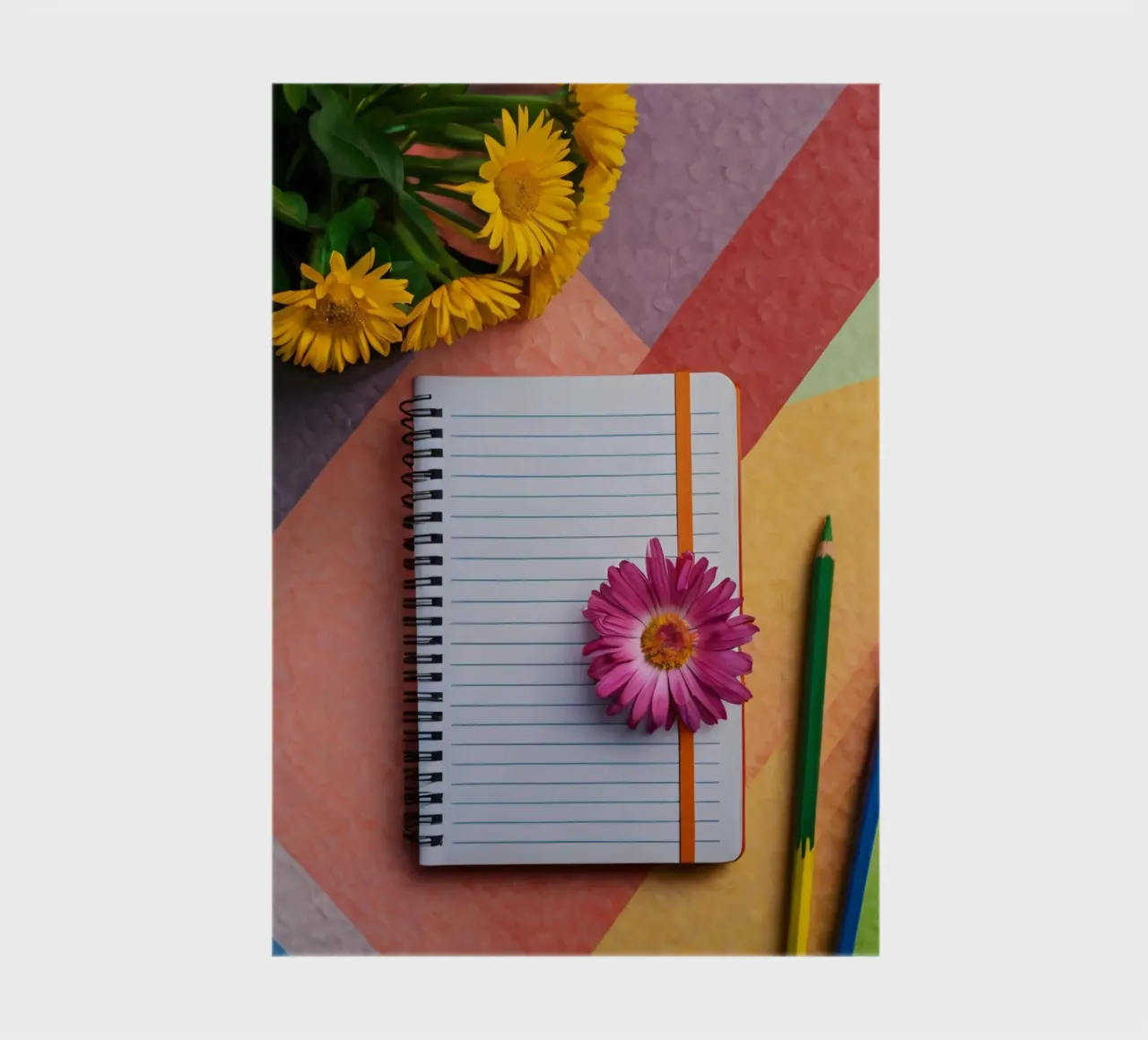 Uno spazio di lavoro colorato con un taccuino con un fiore diario da DesignDoodle