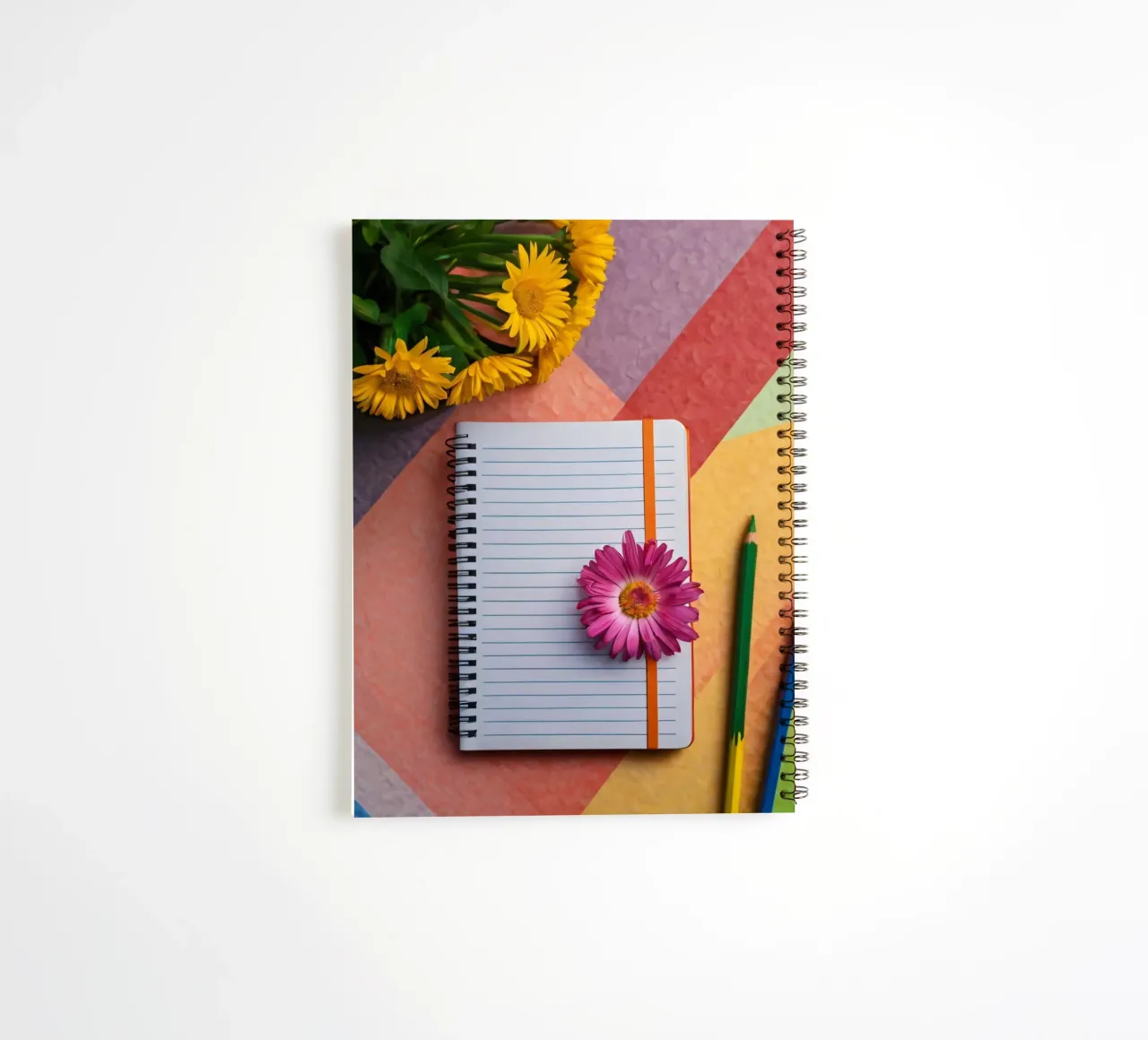 Uno spazio di lavoro colorato con un taccuino con un fiore diario ad anelli da DesignDoodle