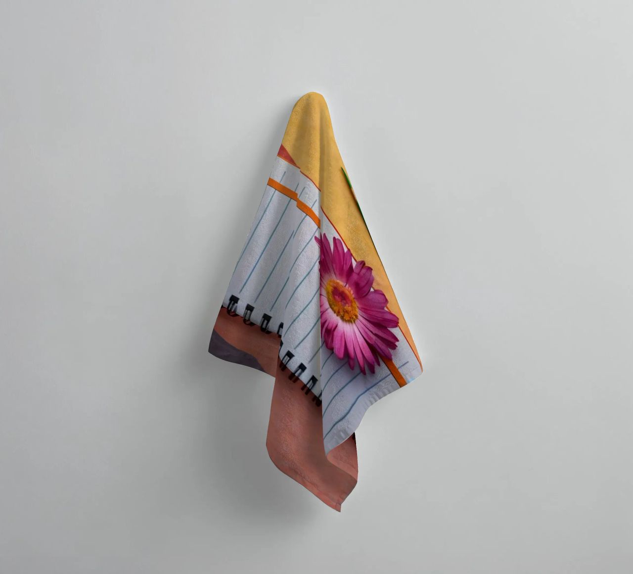 Uno spazio di lavoro colorato con un taccuino con un fiore asciugamano da bagno da DesignDoodle