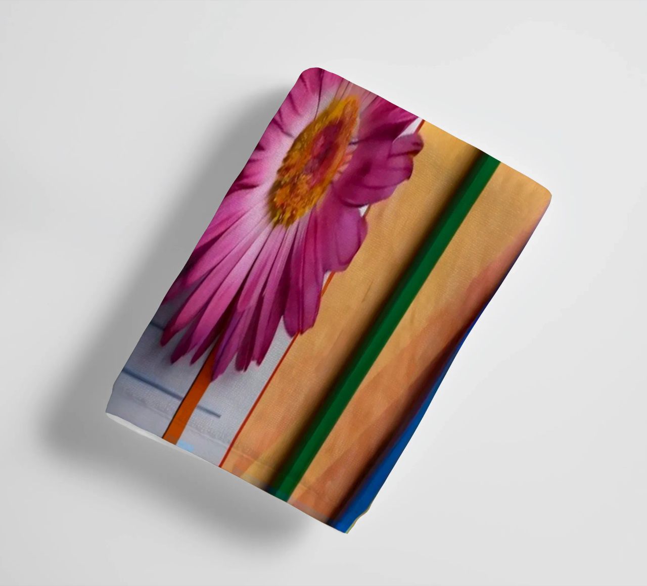 Uno spazio di lavoro colorato con un taccuino con un fiore asciugamano da bagno da DesignDoodle