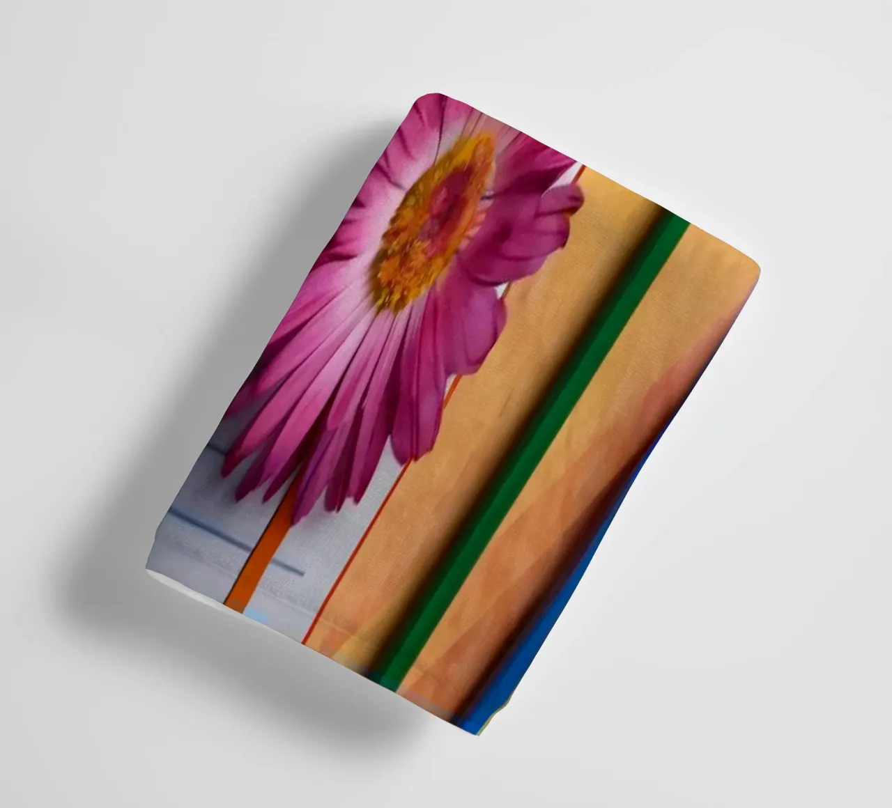 Uno spazio di lavoro colorato con un taccuino con un fiore asciugamano da bagno da DesignDoodle