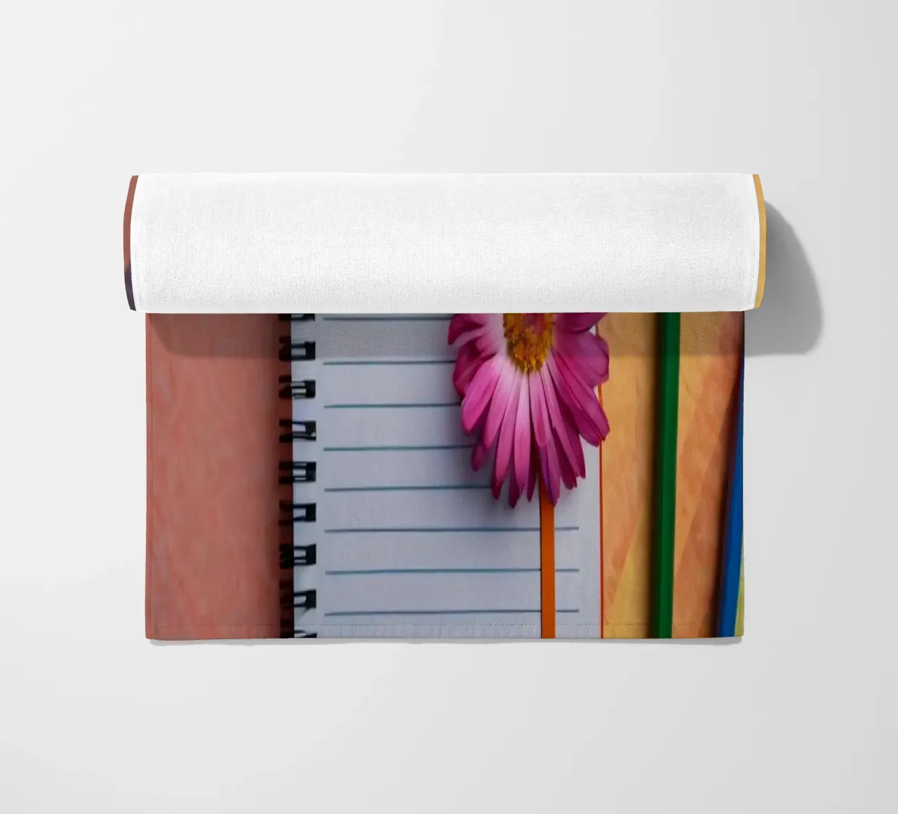 Uno spazio di lavoro colorato con un taccuino con un fiore telo mare da DesignDoodle