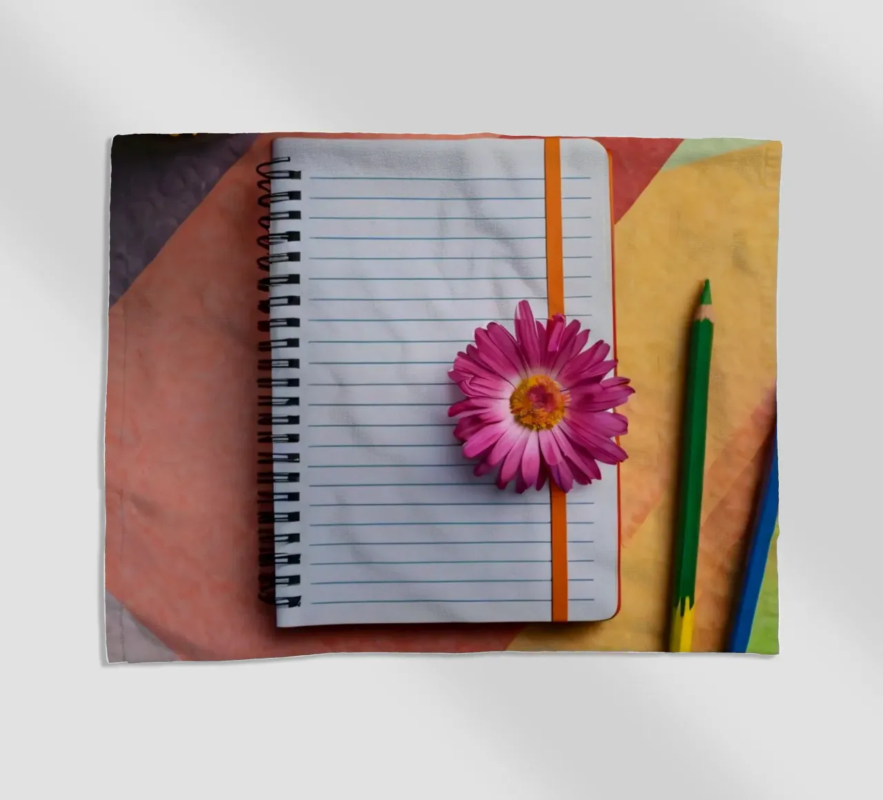 Colorful workspace featuring a notebook with a flower beach towel by DesignDoodle