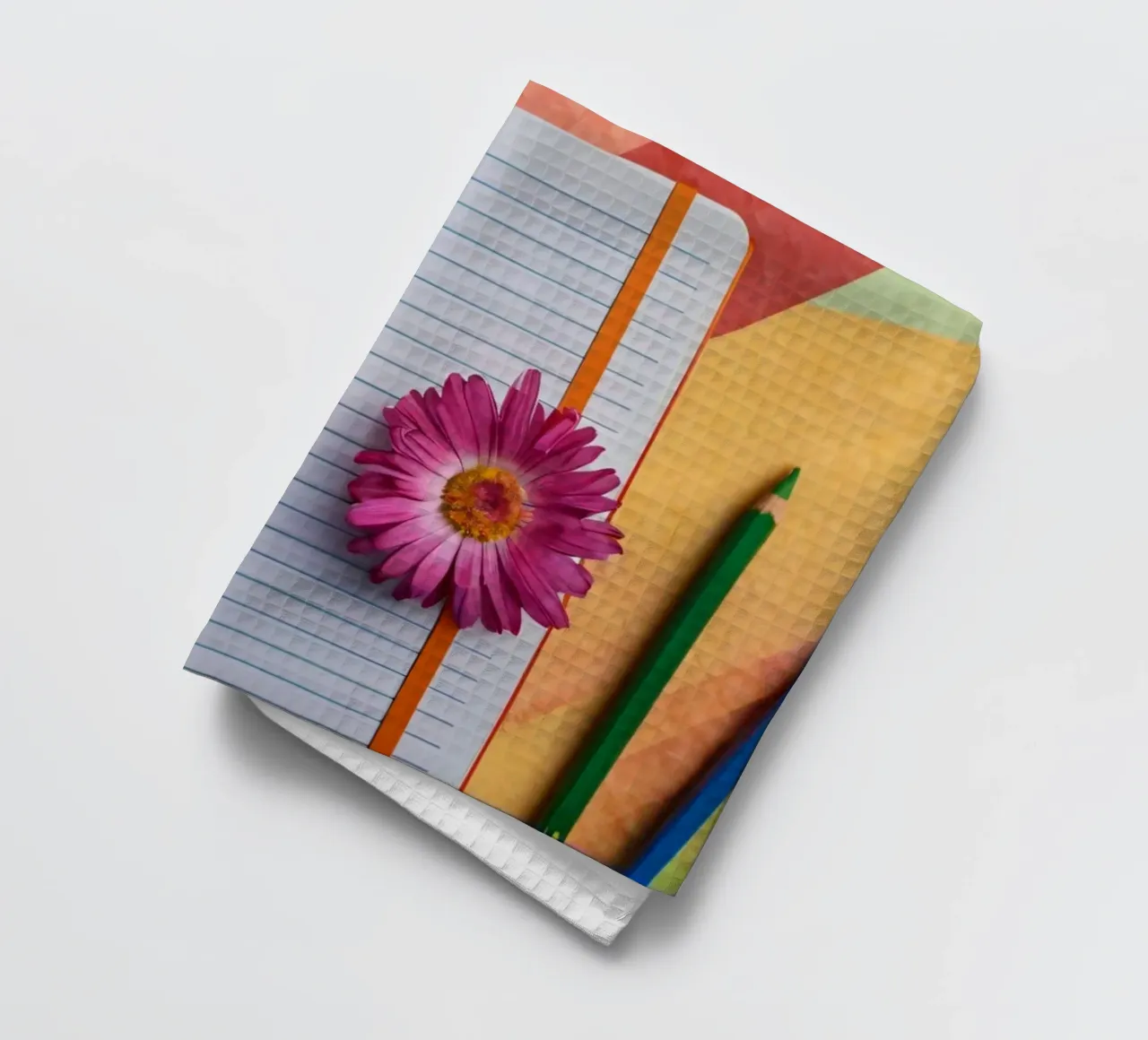 Espace de travail coloré comprenant un cahier avec une fleur torchon de DesignDoodle