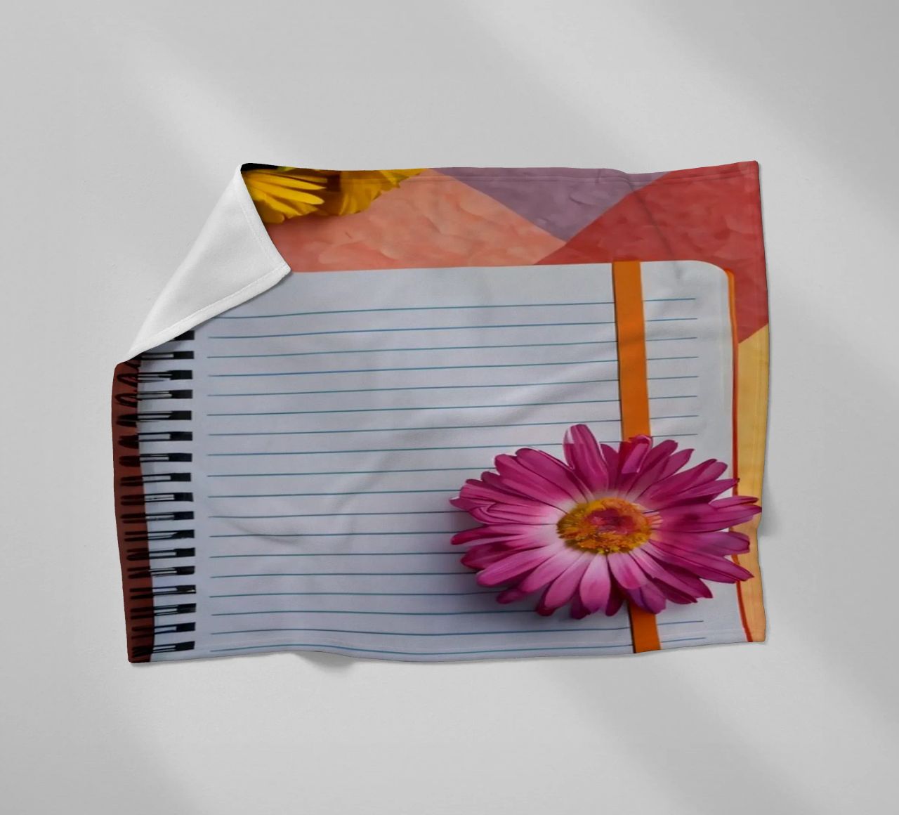 Uno spazio di lavoro colorato con un taccuino con un fiore coperta in pile da DesignDoodle