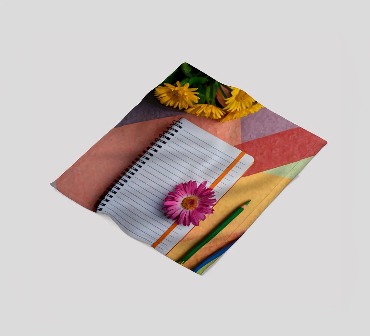 Uno spazio di lavoro colorato con un taccuino con un fiore coperta in pile da DesignDoodle