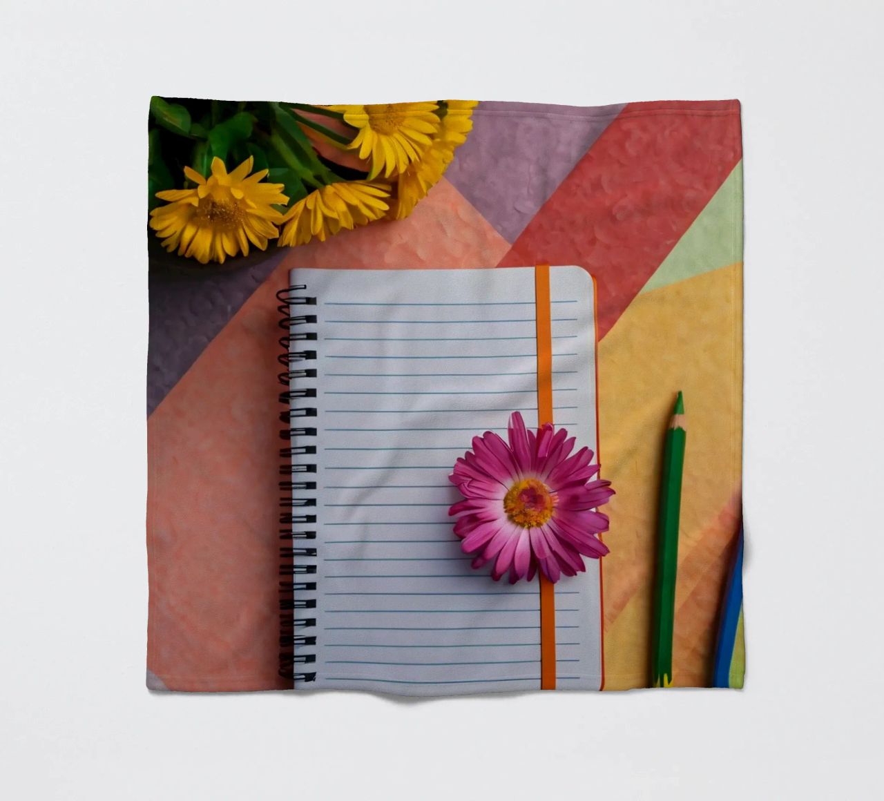 Uno spazio di lavoro colorato con un taccuino con un fiore coperta in pile da DesignDoodle