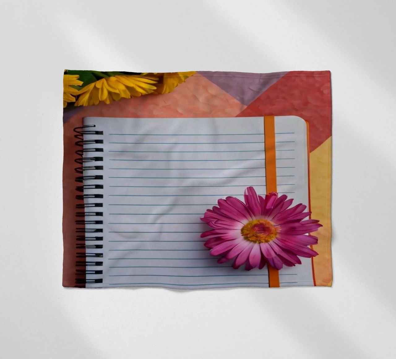 Uno spazio di lavoro colorato con un taccuino con un fiore coperta in pile da DesignDoodle
