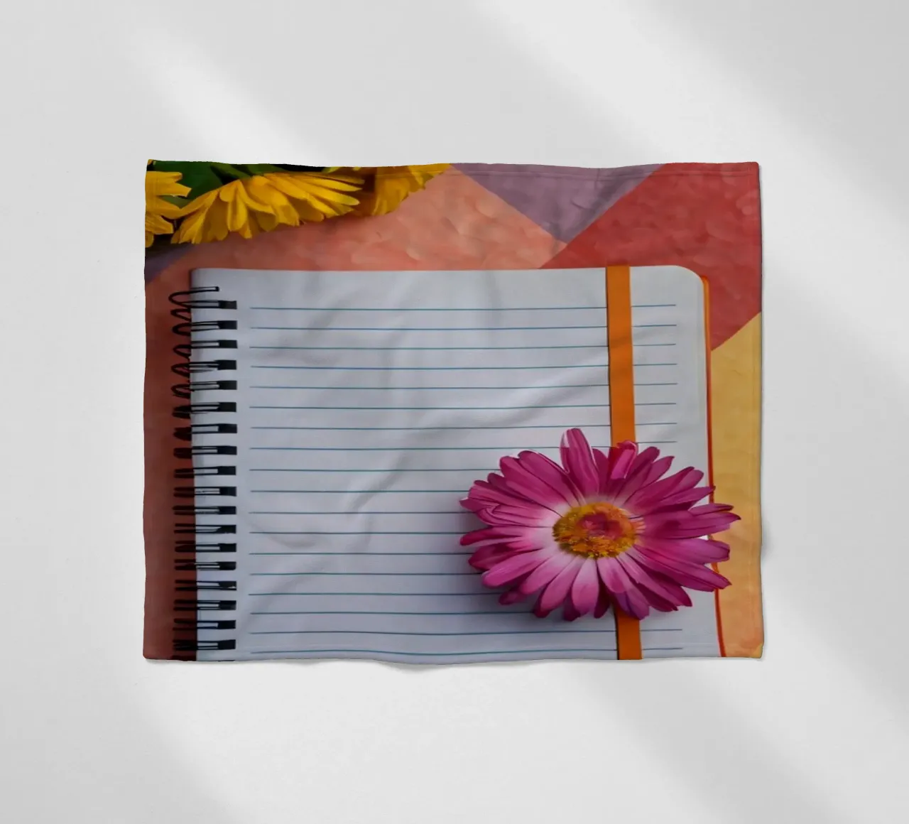 Uno spazio di lavoro colorato con un taccuino con un fiore coperta in pile da DesignDoodle