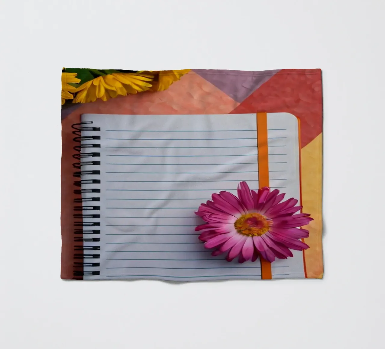 Uno spazio di lavoro colorato con un taccuino con un fiore coperta in pile da DesignDoodle