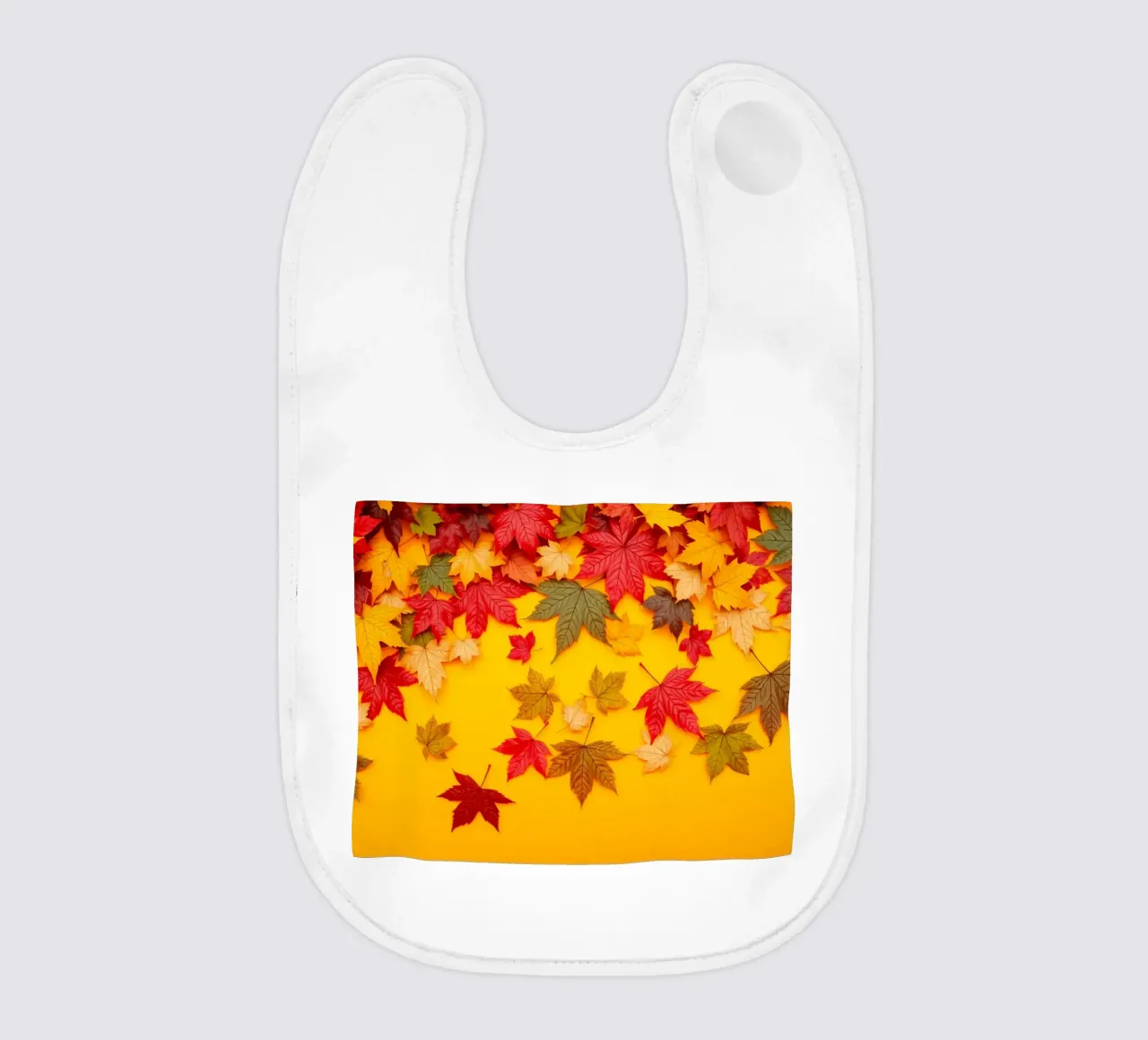 foglie autunnali sparse su uno sfondo giallo caldo bavaglino da DesignDoodle