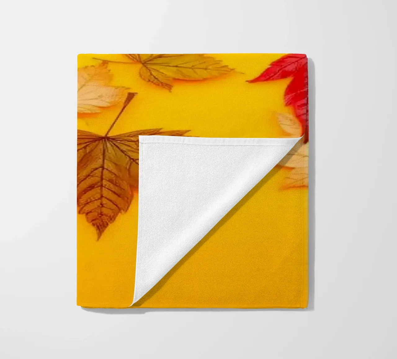 feuilles d'automne dispersées sur un fond jaune chaud serviette de plage de DesignDoodle