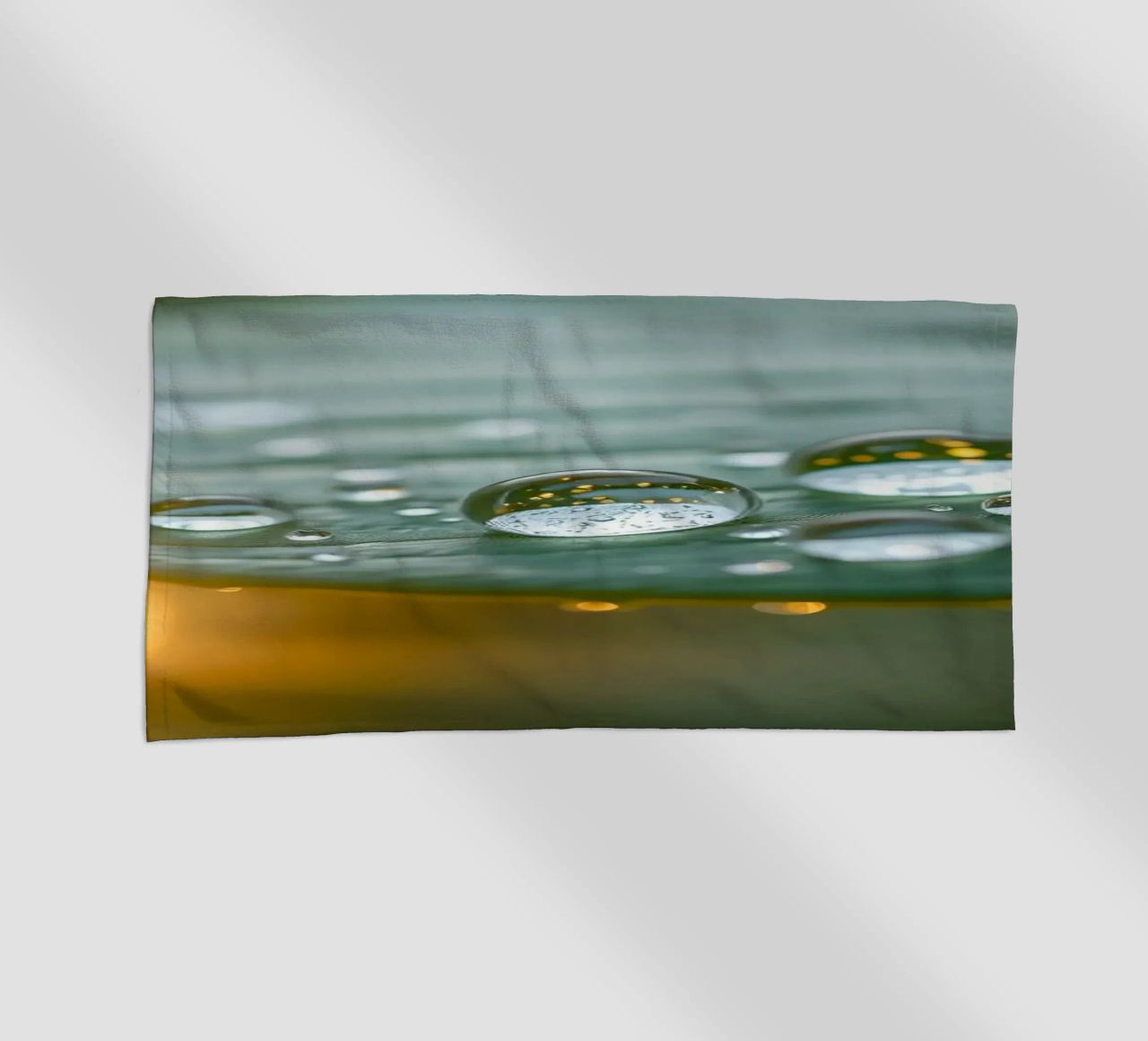 Vue rapprochée de gouttelettes d'eau sur une feuille verte serviette de plage de DesignDoodle