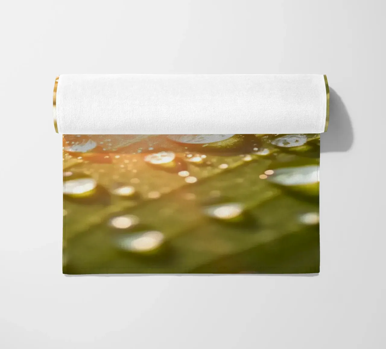 La rugiada mattutina luccica su una foglia verde mentre la luce del sole si infrange telo mare da DesignDoodle