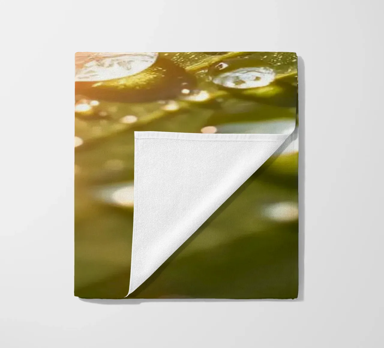 La rugiada mattutina luccica su una foglia verde mentre la luce del sole si infrange telo mare da DesignDoodle