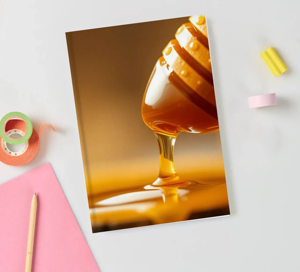 Golden honey drips from a wooden dipper on a rustic wooden notebook by DesignDoodle