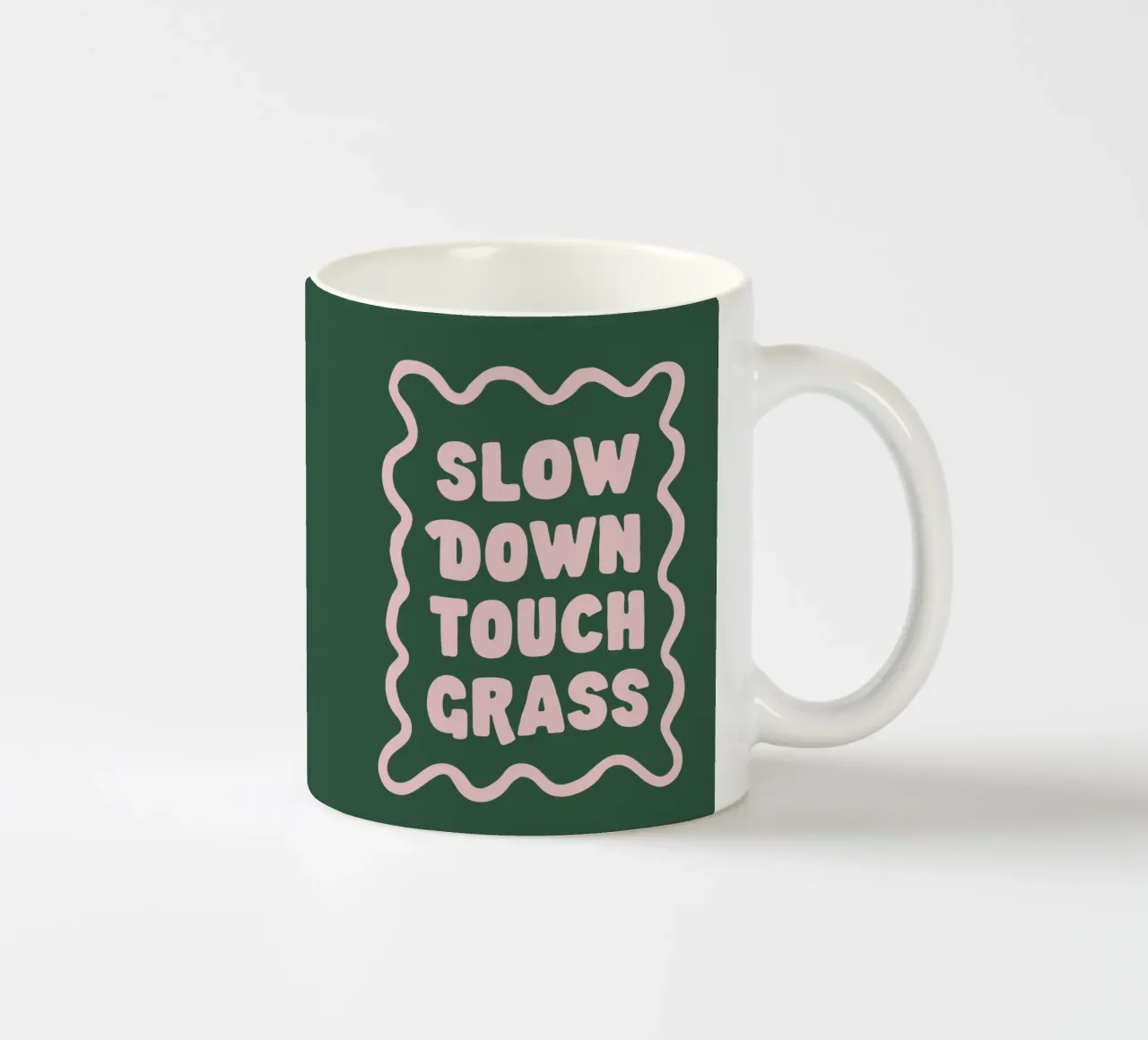 Stampa tipografica Slow Down Touch Grass in verde e rosa tazza in ceramica da THE MOTIVATED TYPE
