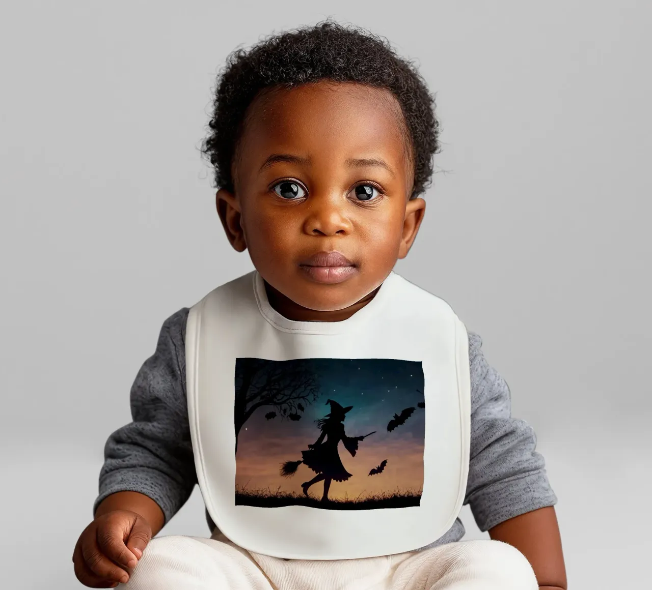 Una strega in controluce che vola su un manico di scopa in un pipistrello crepuscolare bavaglino da DesignDoodle