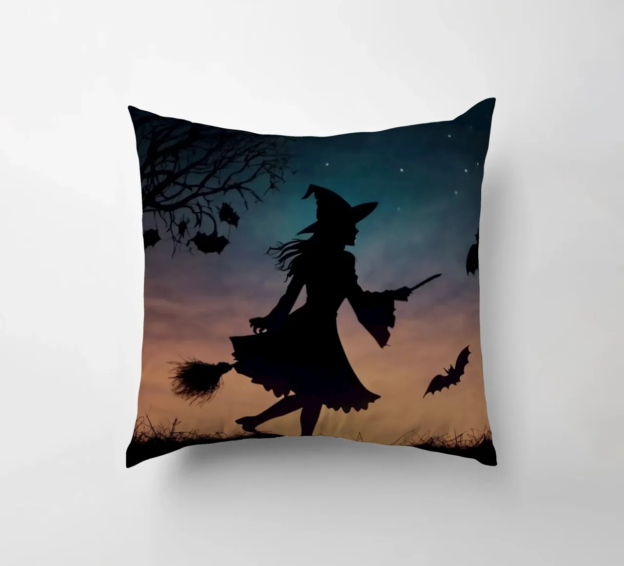 Eine silhouettierte Hexe, die auf einem Besenstiel in einer dämmrigen Fledermaus fliegt Kissen von DesignDoodle