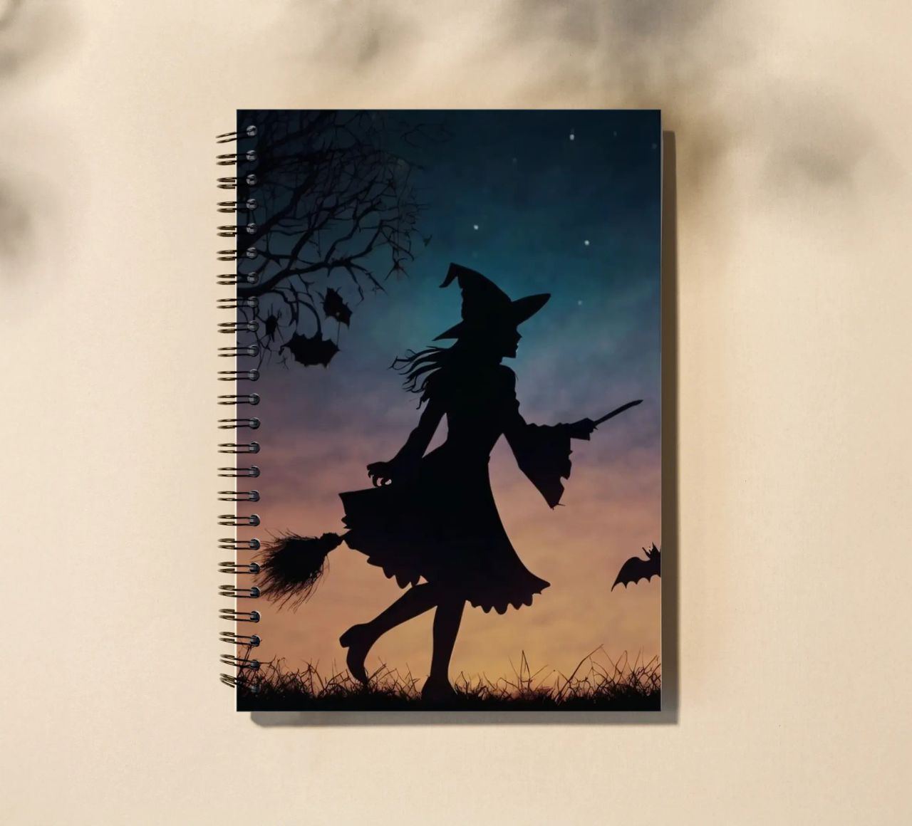 Una strega in controluce che vola su un manico di scopa in un pipistrello crepuscolare diario ad anelli da DesignDoodle