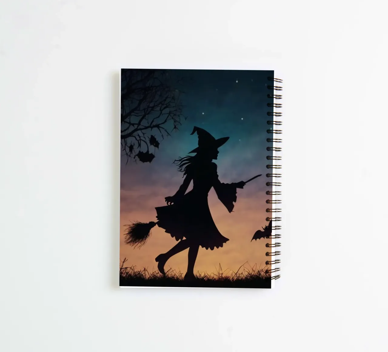 Una bruja silueteada volando en escoba en un murciélago crepuscular cuaderno de espiral de DesignDoodle