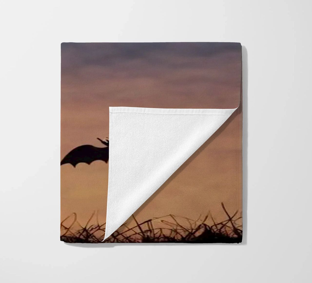 Una strega in controluce che vola su un manico di scopa in un pipistrello crepuscolare telo mare da DesignDoodle