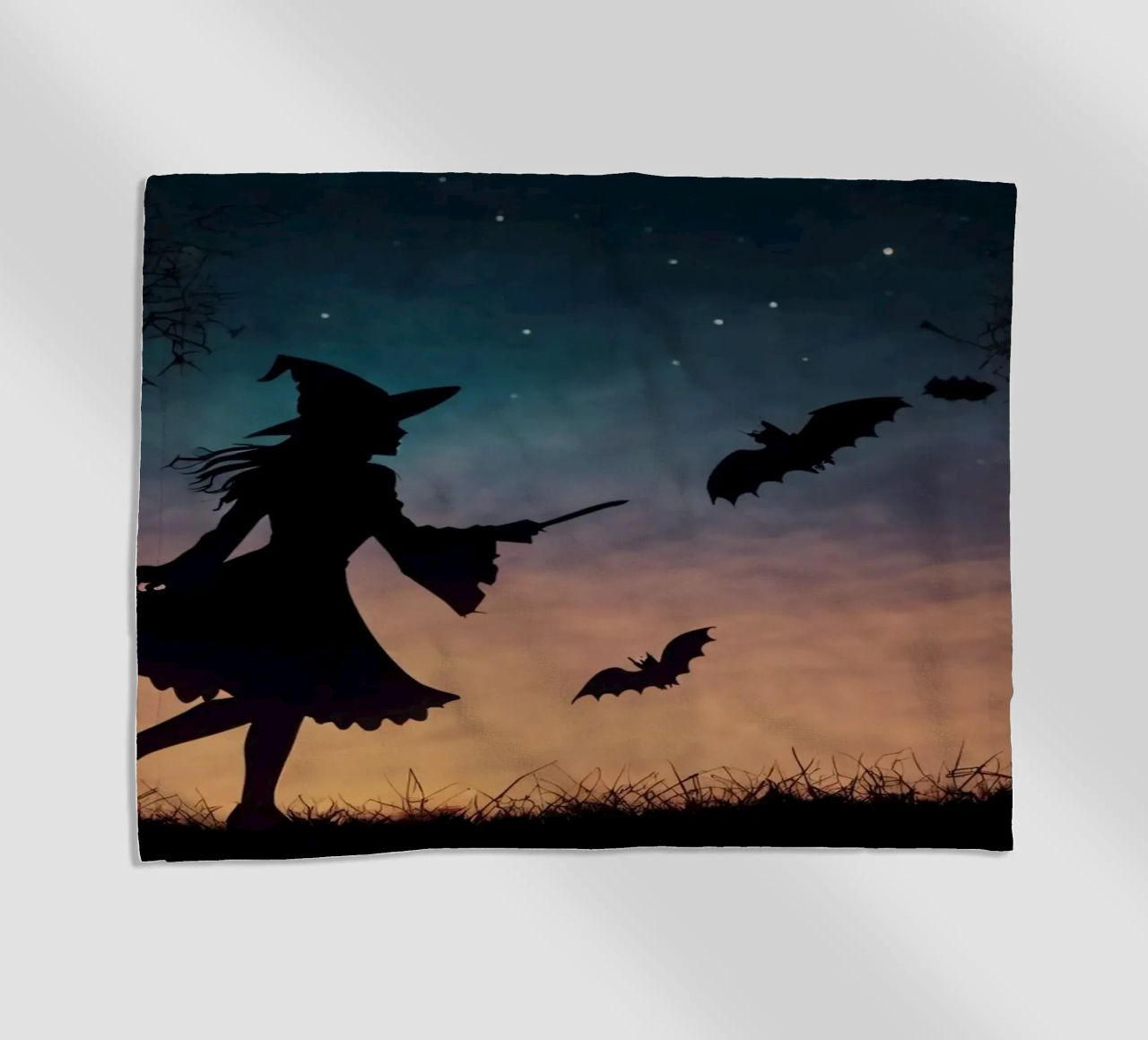 Una strega in controluce che vola su un manico di scopa in un pipistrello crepuscolare telo mare da DesignDoodle