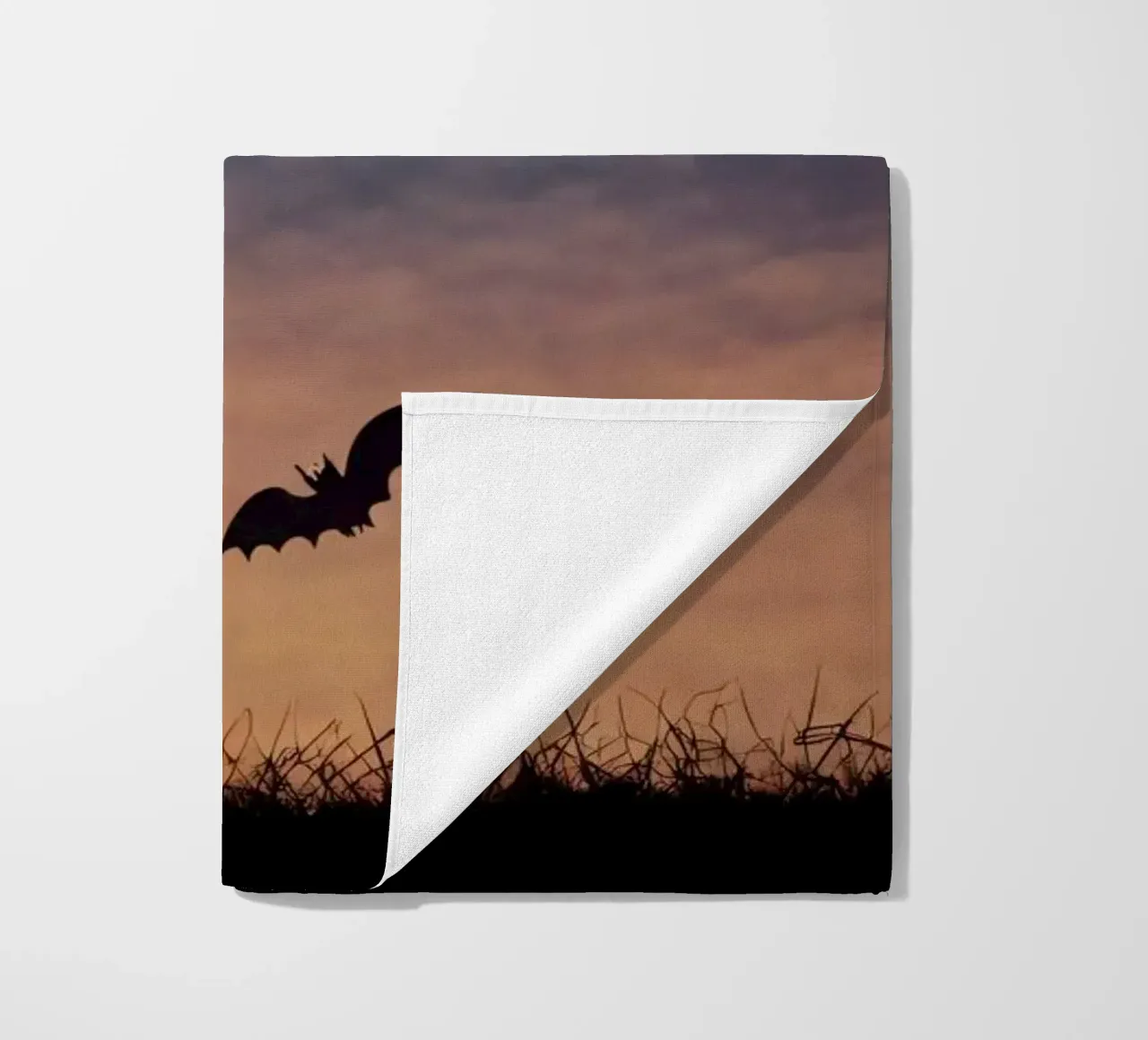 Een silhouet van een heks vliegend op een bezemsteel in een schemerige vleermuis strandhanddoek van DesignDoodle