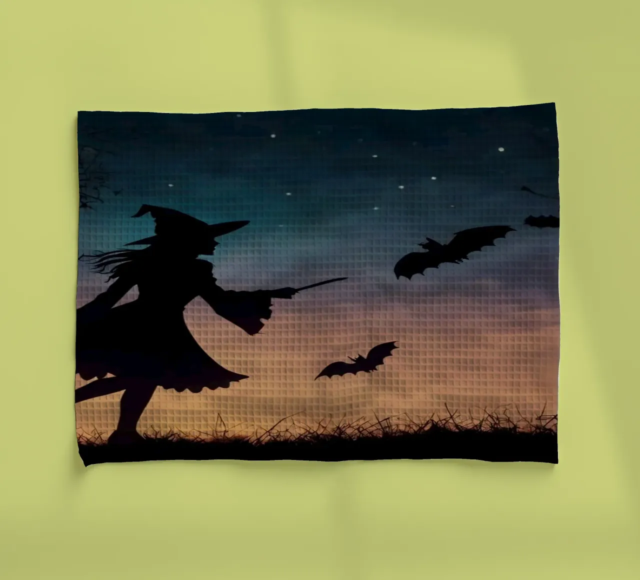 Silhouette d'une sorcière volant sur un balai dans une chauve-souris crépusculaire. torchon de DesignDoodle