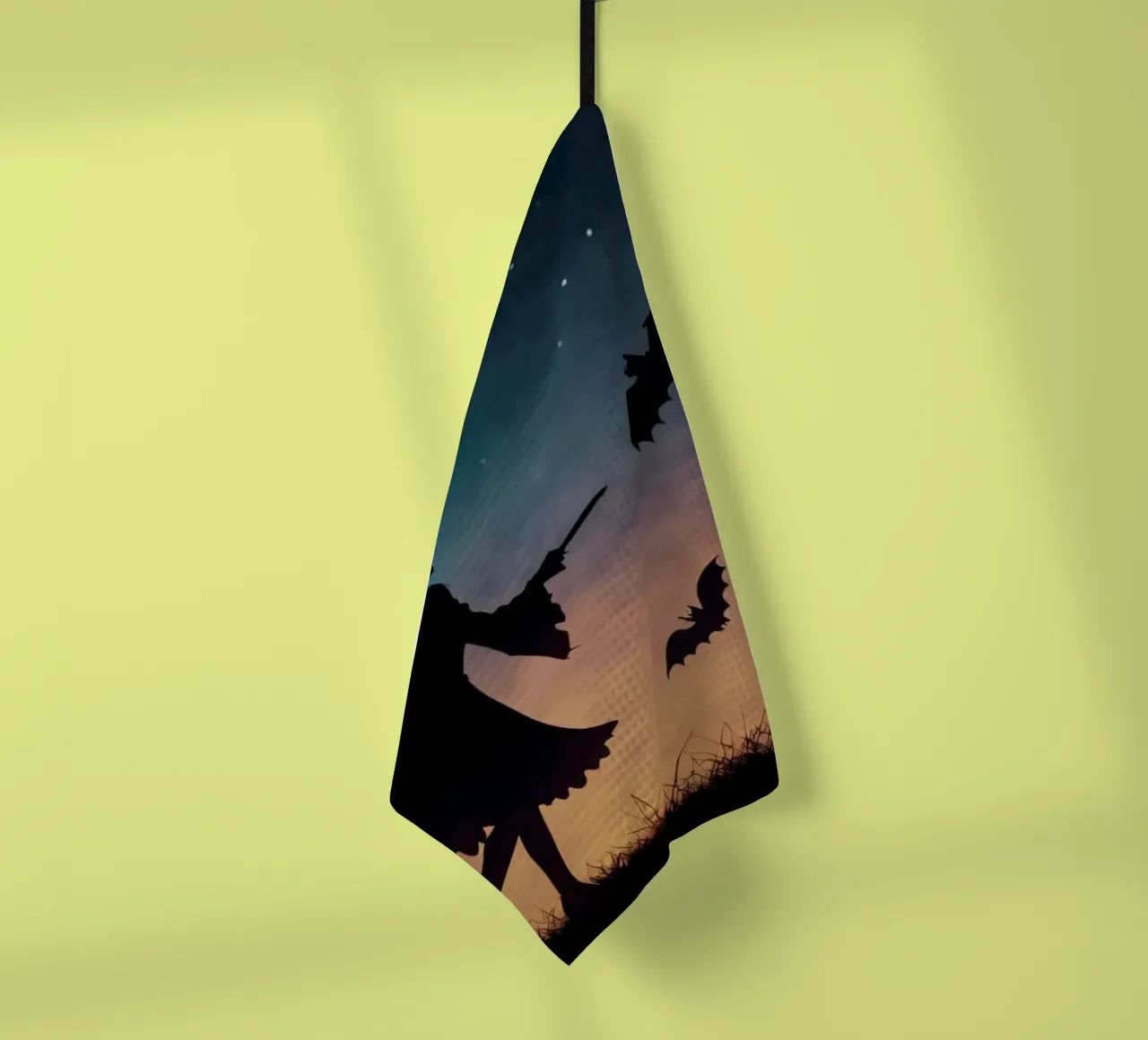 Silhouette d'une sorcière volant sur un balai dans une chauve-souris crépusculaire. torchon de DesignDoodle