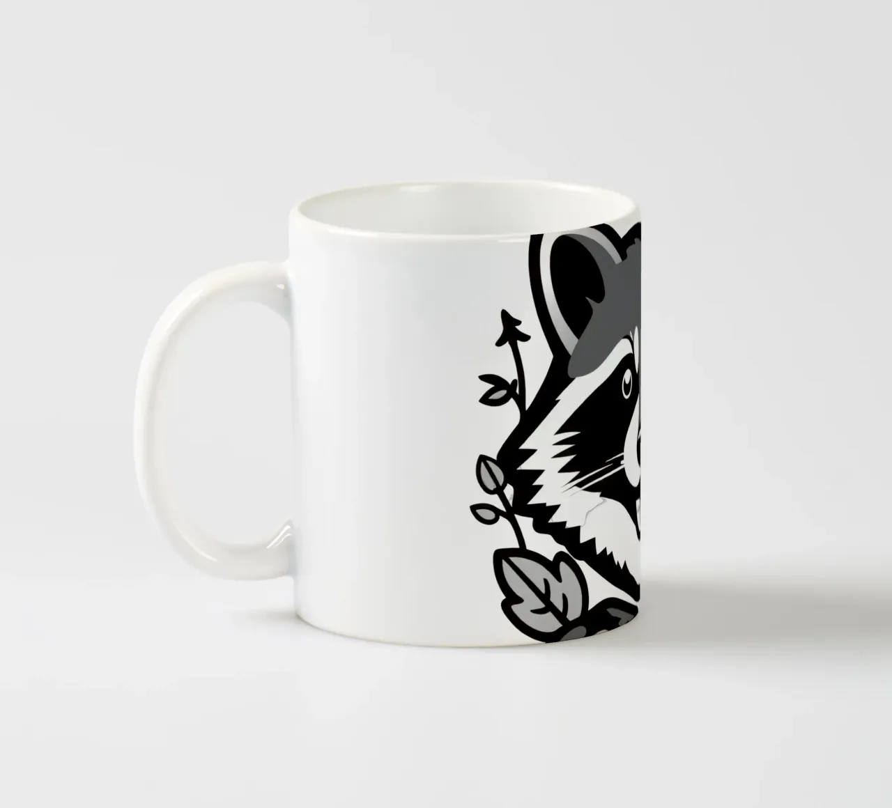 Illustrazione di procione giocoso circondato da foglie e rami tazza in ceramica da DesignDoodle
