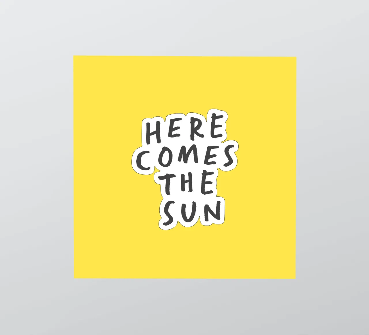 Impression typographique Here Comes the Sun en jaune et noir autocollant de THE MOTIVATED TYPE