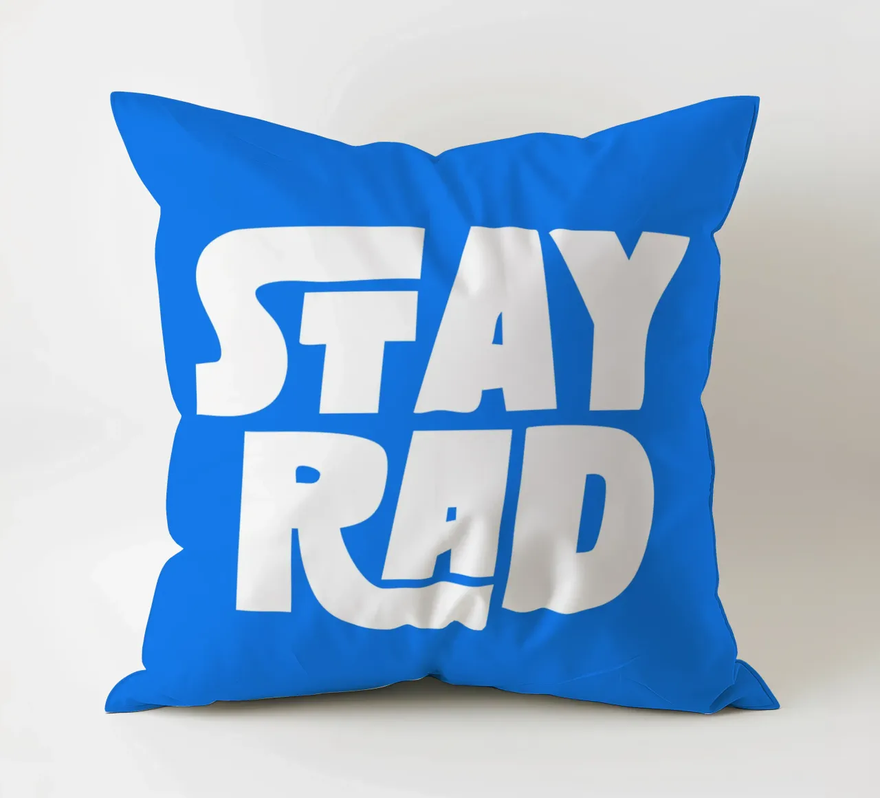 Stay Rad Stampa tipografica in grassetto retrò e vivace in blu e bianco cuscino da THE MOTIVATED TYPE