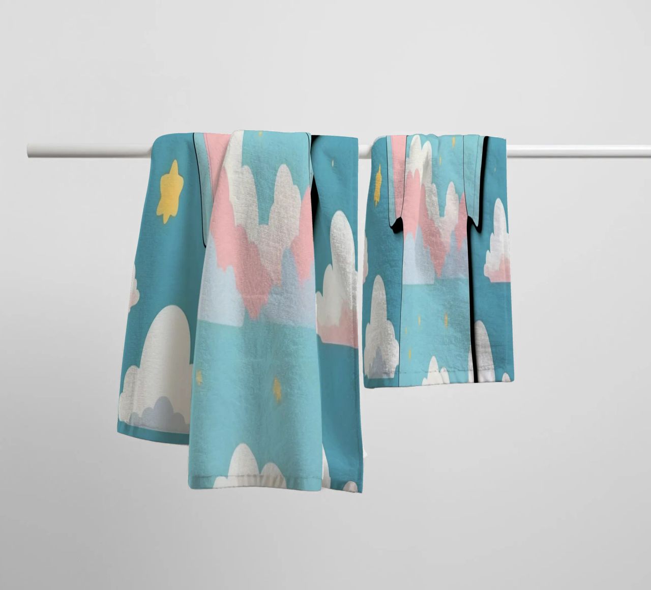Grenouillère pour bébé avec motif de nuages en bleu, rose et jaune. serviette de bain de DesignDoodle
