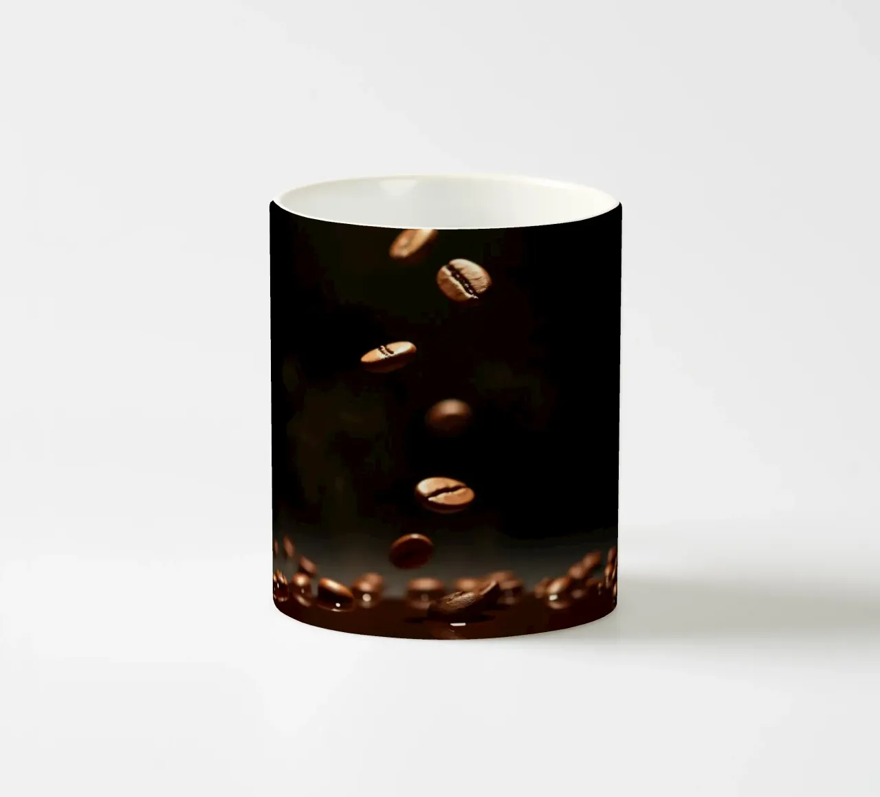 Chicchi di caffè che cadono con grazia sopra una pozza di caffè fresco tazza in ceramica da DesignDoodle