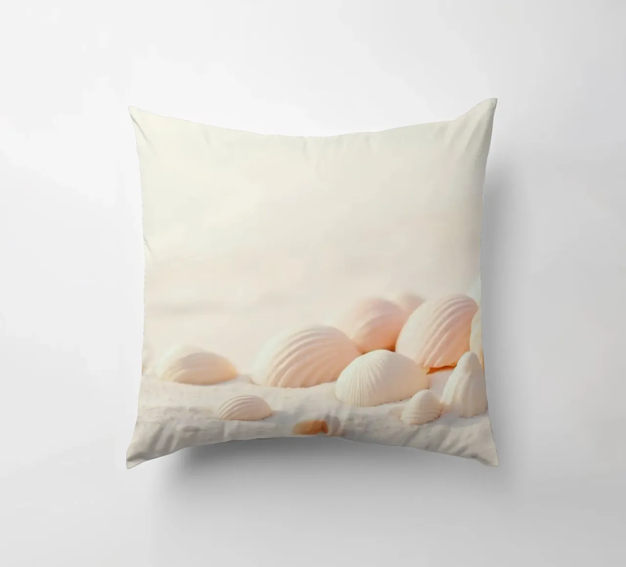 Conchiglie sparse su una spiaggia sabbiosa durante la mattina presto cuscino da DesignDoodle