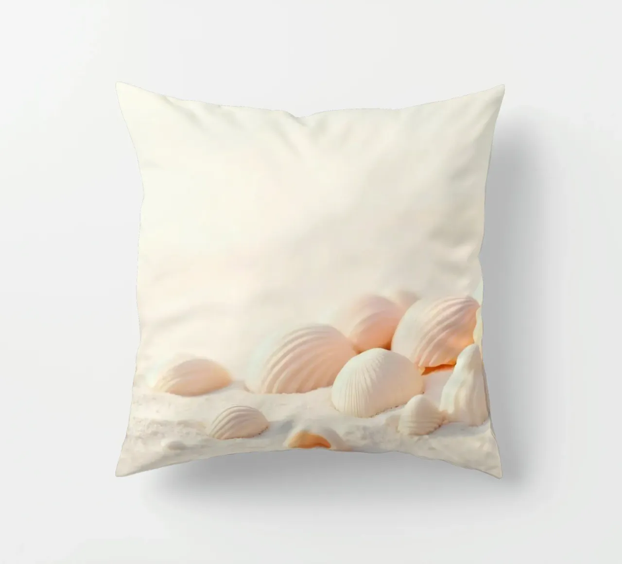 Conchiglie sparse su una spiaggia sabbiosa durante la mattina presto cuscino da DesignDoodle