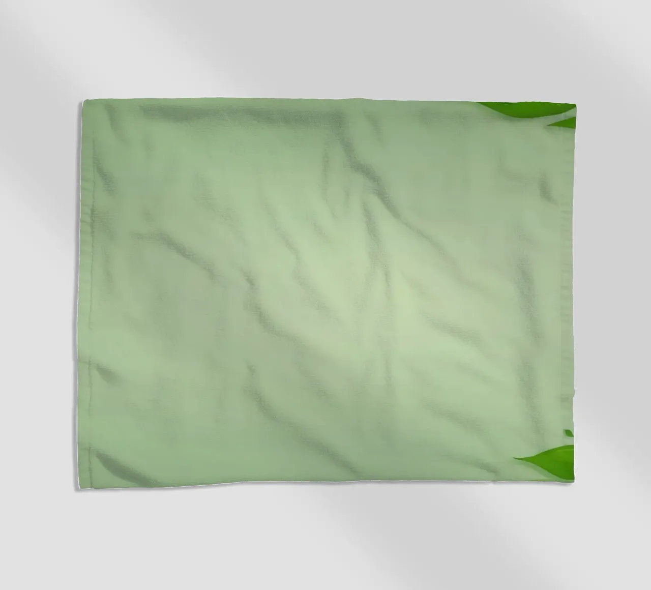 Green leaves on a soft background create a calming and fresh beach towel by DesignDoodle