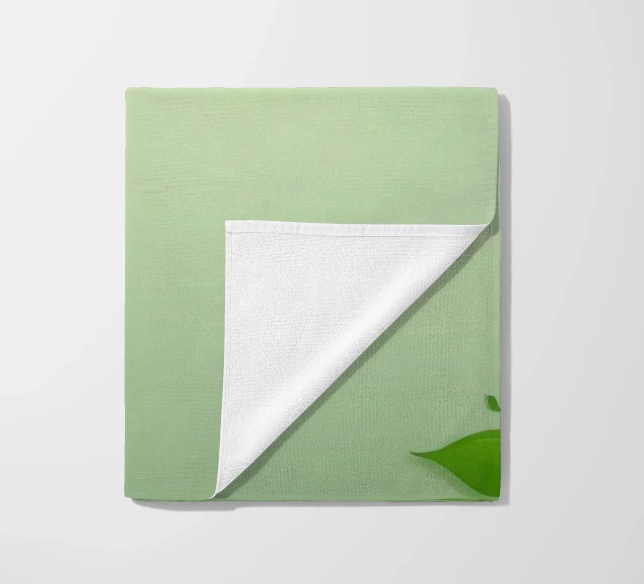 Green leaves on a soft background create a calming and fresh beach towel by DesignDoodle