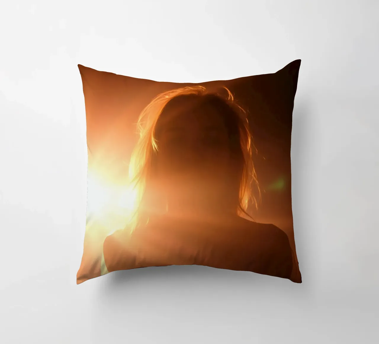 La luce soffusa crea la silhouette di una persona in una calda luminosità cuscino da DesignDoodle