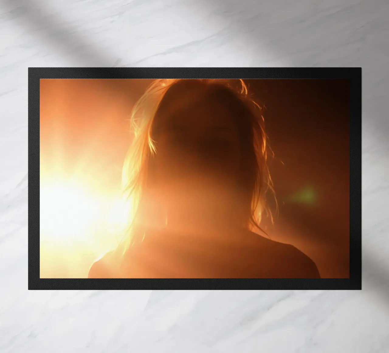 La luce soffusa crea la silhouette di una persona in una calda luminosità zerbino da DesignDoodle