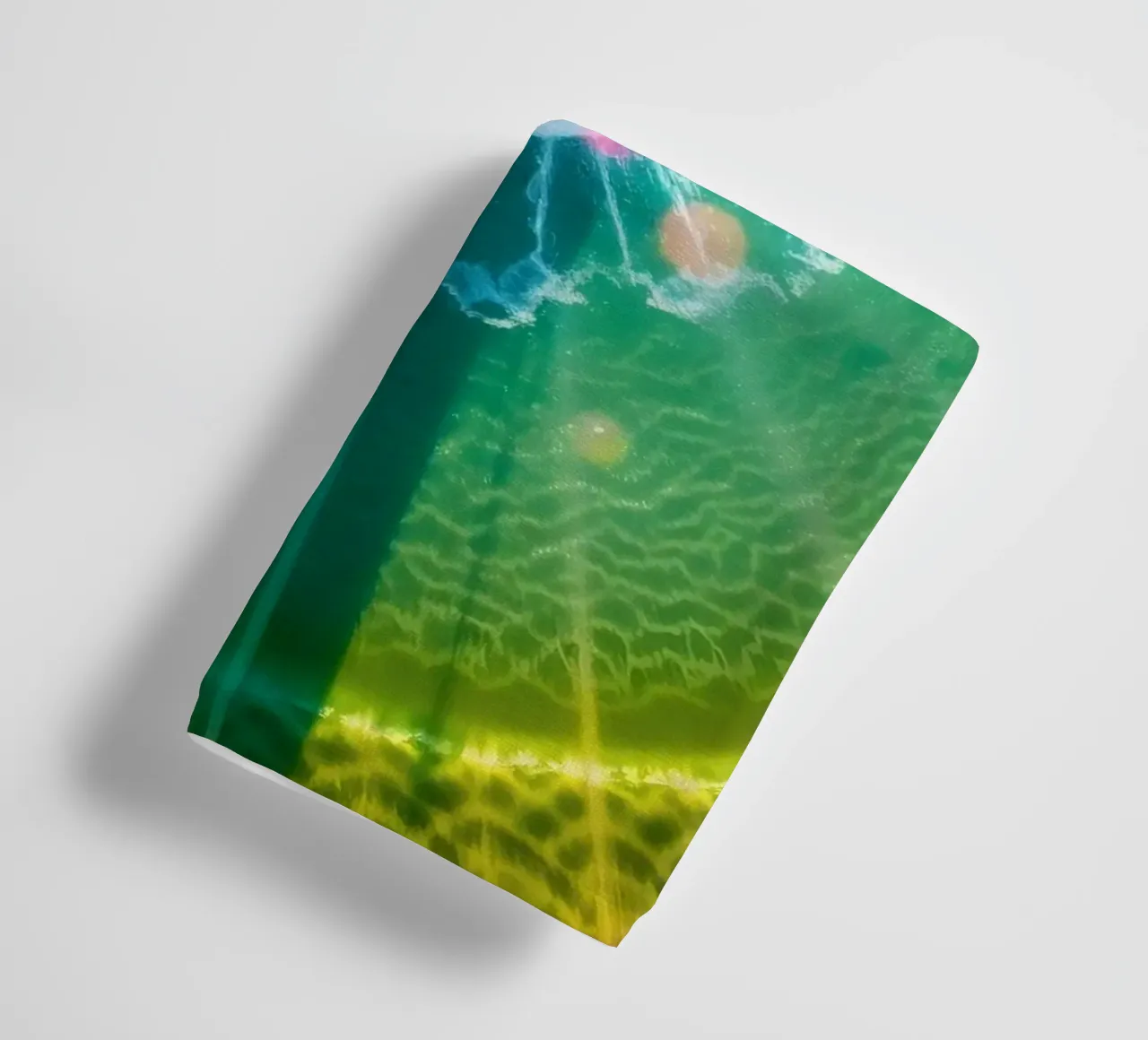 vue aérienne d'une fontaine avec des reflets lumineux colorés serviette de bain de DesignDoodle