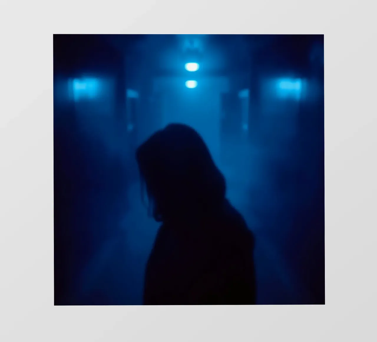 Donna in un corridoio poco illuminato con luci blu e nebbia pellicola backlit da DesignDoodle