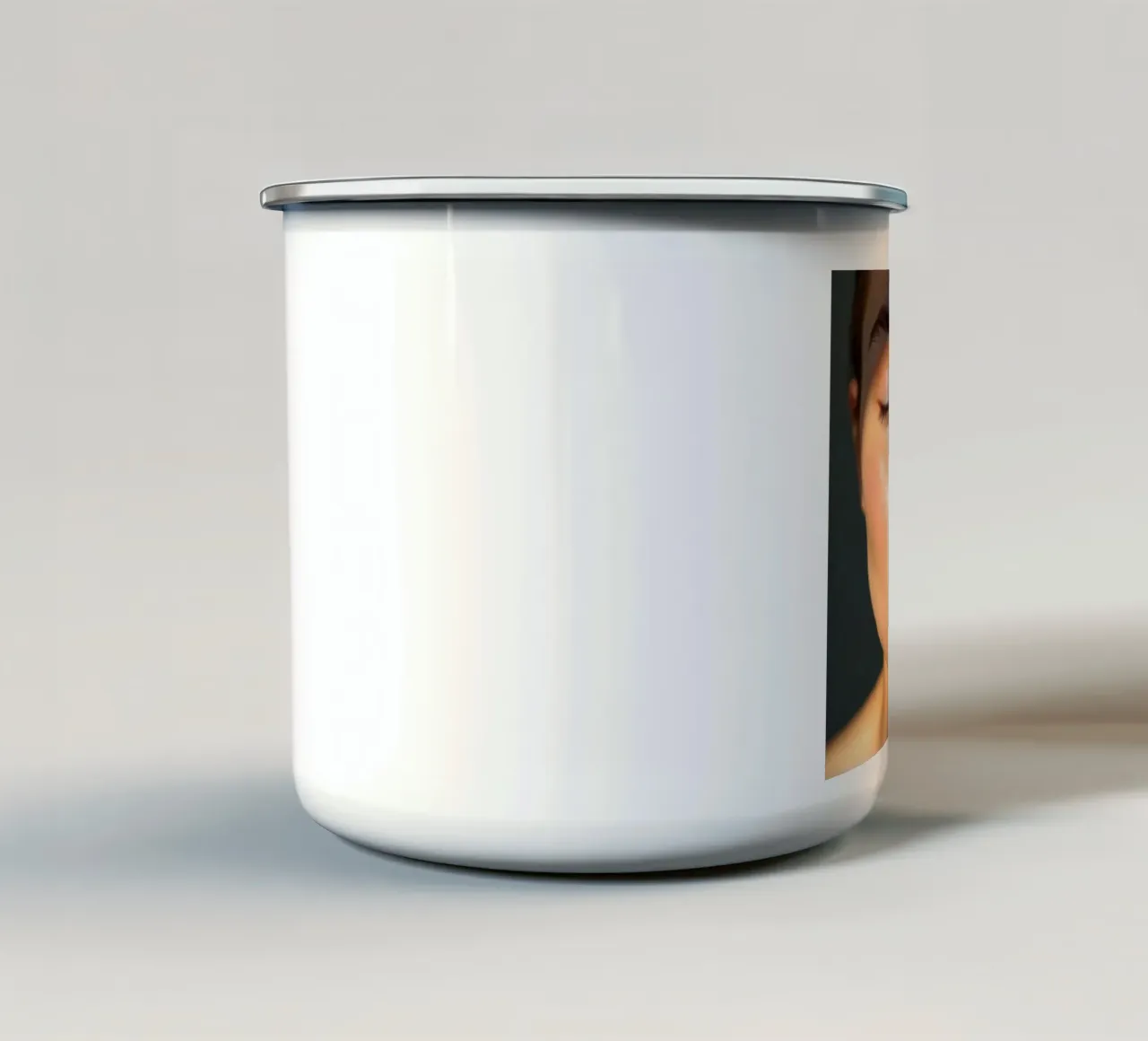 Una luce morbida che crea ombre delicate su un viso sereno tazza in smalto da DesignDoodle