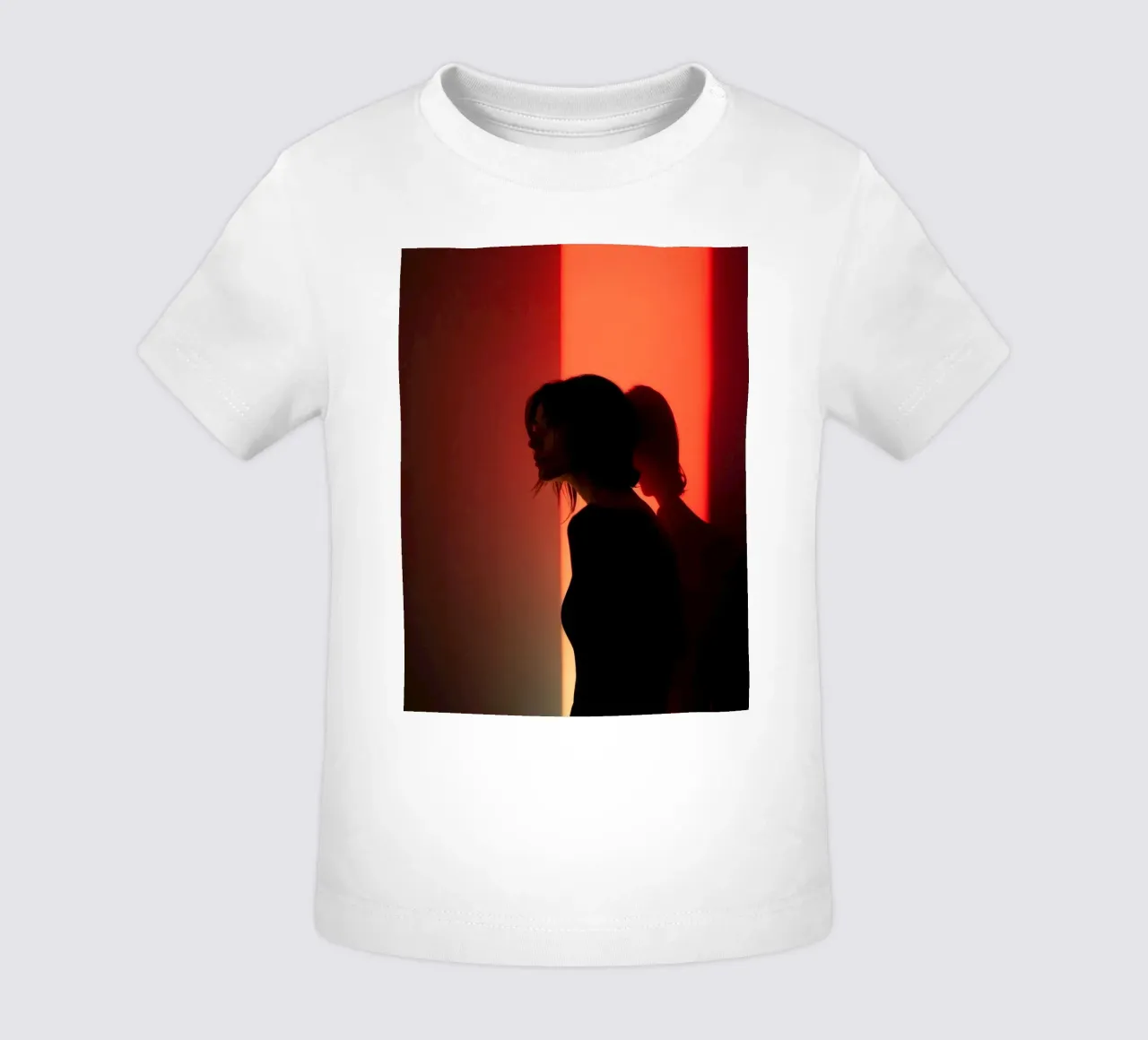 Silhouette d'une femme dans une lumière tamisée sur fond coloré t-shirt pour bébé de DesignDoodle